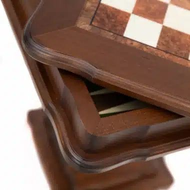 Gros plan sur le bord sculpté du plateau et le pied de la table