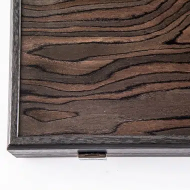 Détail de l'angle du coffret fermé avec fermoir discret et veines du placage
