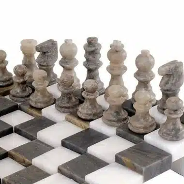 Pièces d'échecs en marbre gris alignées sur l'échiquier 3D antique