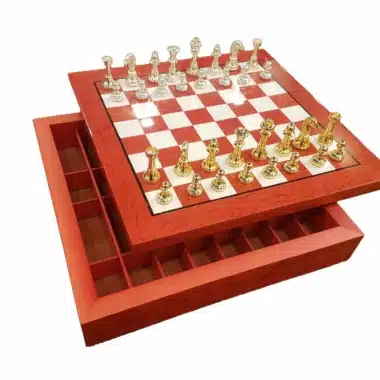 Ensemble échiquier moderne rouge et blanc avec pièces en laiton doré et argenté, coffret ouvert
