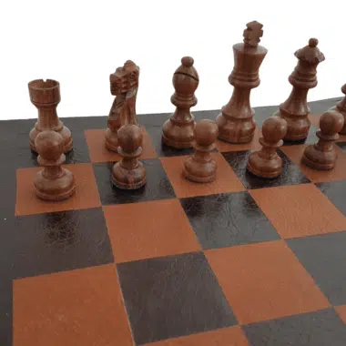 Pièces en bois de rose doré en gros plan sur l'échiquier en cuir, tour, cavalier et fou