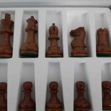 Pièces foncées du jeu Staunton Printemps alignées dans leur coffret, gros plan