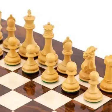 Pièces d'échecs en buis clair rangées face aux pièces noires sur l'échiquier