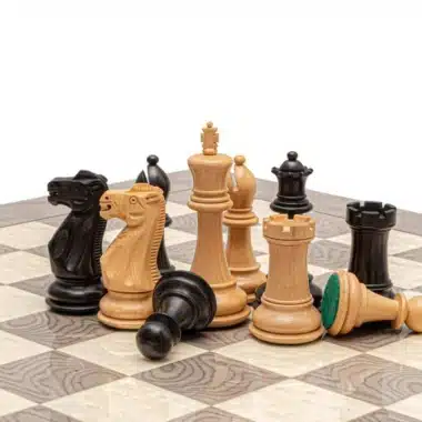 Pièces d'échecs en buis et buis ébénisé posées sur l'échiquier en loupe de frêne