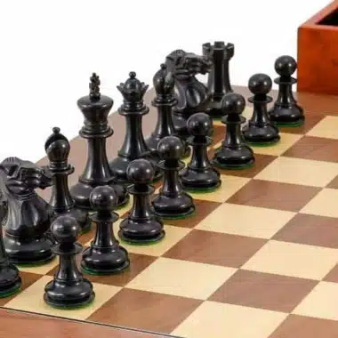 Rangée de pièces noires ébonisées alignées sur l'échiquier avec coffret en arrière-plan