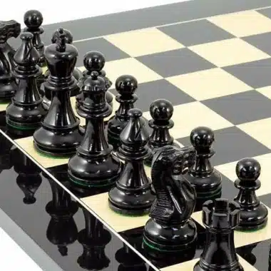 Détail des pièces noires alignées face au cavalier sculpté sur l'échiquier