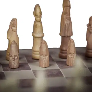 Pièces d'échecs en pierre ollaire, détail des visages sculptés sur l'échiquier