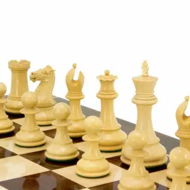 Pièces d'échecs claires en buis disposées sur un échiquier en marqueterie