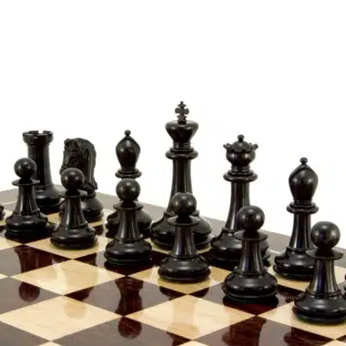 Pièces noires du jeu d'échecs en ébène disposées sur un échiquier en bois
