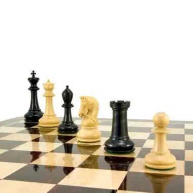 Rangée de pièces d'échecs en ébène et buis sur un échiquier verni
