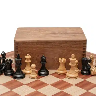 Coffret de rangement en bois de rose fermé entouré des pièces Staunton sur l'échiquier